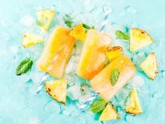 pineapple and mint ice pops with mint leaves on blue background, top view from above