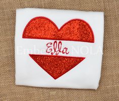 a red heart with the word ella on it is embroidered onto a white t - shirt