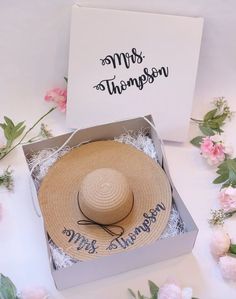 a hat in a box with flowers around it