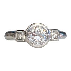 Details: Modern vintage with a sweet heart carved into the side of this Mid-Century 1940's Platinum Diamond ring. This ring has a round brilliant cut measuring .83cts, with a combined total weight of just under one carat—.98 carats. A classic, and timeless style, full of sparkle and flare this ring would make a perfect engagement ring. This ring comes with an appraisal. Please ask all necessary questions prior to placing an order. Appraisal reads: Platinum diamond ring. Bezel set in the center i