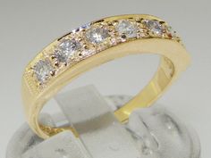 a yellow gold ring with five diamonds on it's side and in the middle