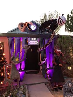 some creepy people are standing in front of a house with purple lights and decorations on it