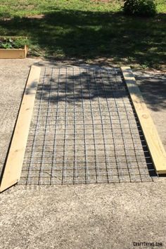 a metal grate sitting on top of concrete next to a grass covered park area