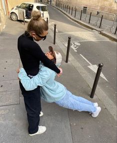 two people are hugging on the street