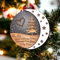 a wooden ornament hanging from a christmas tree decorated with stars and a heart