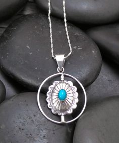 This pendant is handcrafted with Sterling Silver and is set with Turquoise and Coral stones into a concho design. This pendant features a spinner that allows you to turn to the side you want. You can wear it as a Turquoise pendant one day, and a Coral pendant the next. The styling is soft, modern, and lightweight. It'll compliment any outfit that is worn with this. Measures: 1 11/16” x 1 1/8” Includes 20" Silver Chain Vintage never worn Southwestern Concho Necklace As Gift, Southwestern Style Concho Necklace As Gift, Southwestern Style Concho Necklace For Gift, Southwestern Silver Turquoise Necklace With Round Pendant, Silver Southwestern Turquoise Necklace With Round Pendant, Artisan Turquoise Concho Necklace Gift, Southwestern Sterling Silver Turquoise Concho Necklace, Southwestern Style Concho Pendant Jewelry, Sterling Silver Turquoise Necklace With Concho