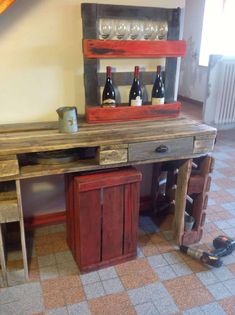 a wooden table with wine bottles on it in a room filled with tile flooring