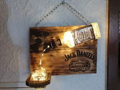 a wooden sign hanging from the side of a wall next to a lit up mason jar