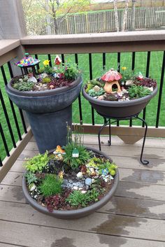 two potted plants are sitting on the porch with little fairy figurines in them