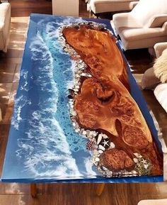 the table is made out of wood and has an ocean scene on it, along with white chairs