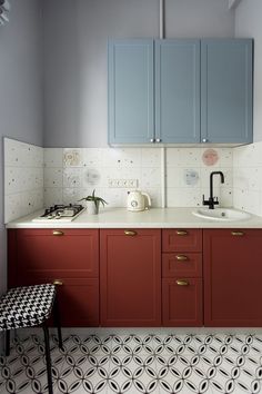 a kitchen with red cabinets and white counter tops