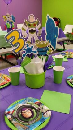 the table is set with plates, cups and napkins for children's birthday party