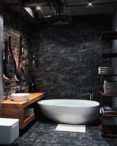 a large white bath tub sitting next to a wooden shelf filled with towels and other bathroom accessories