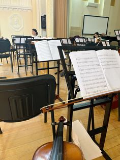 an orchestra room filled with musical instruments and music sheets on the desks in front of them