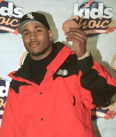 a man in an orange and black jacket holding a doughnut