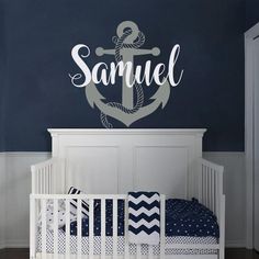 a baby's room with an anchor and name decal on the wall