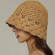 a woman wearing a brown crocheted hat