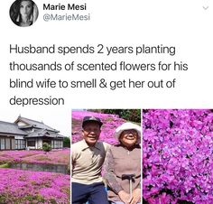 two people standing next to each other in front of purple flowers and a white house