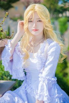 a woman with long blonde hair wearing a white dress and holding a planter in her hand