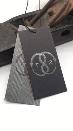 a black and silver tag with the letter s on it