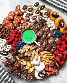 a platter filled with cookies, pretzels, and other snacks on top of a marble table