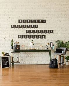 a room with white brick walls and wooden floors, decorated with letters that spell out the word