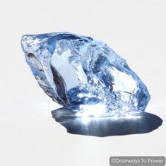 a large diamond is sitting on the ground with its reflection in it's surface