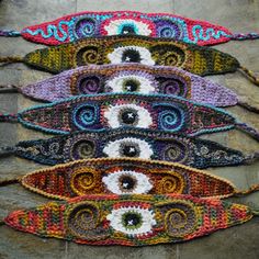 five crocheted eyeballs are displayed on a stone wall in the shape of an eye