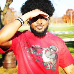 a man with an afro wearing sunglasses and a red shirt