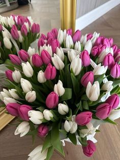 a bouquet of pink and white tulips in front of a mirror