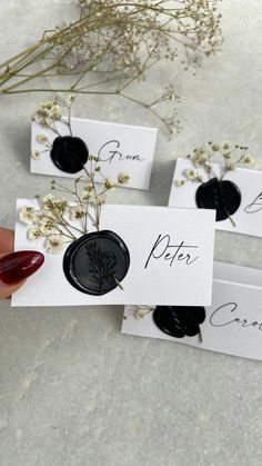 three black and white place cards with flowers on them