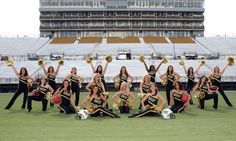 a group of cheerleaders pose for a photo in front of an empty stadium