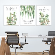 three green watercolor paintings on a white wall above a desk with a black chair