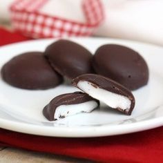 three chocolate covered desserts on a white plate