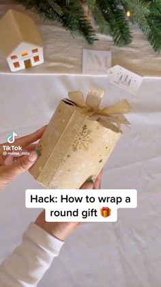 a person holding a wrapped gift box with the words hack how to wrap a round gift