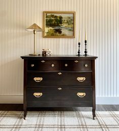 a dresser with two lamps on top of it