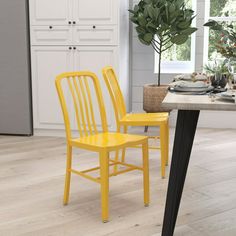 two green chairs sitting next to each other on a wooden floor in front of a kitchen