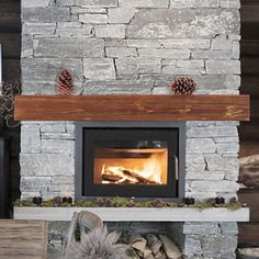 a fireplace with logs and pine cones on the mantle