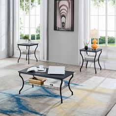 a living room with two tables and one end table on the floor in front of windows