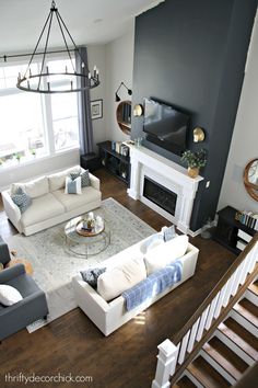 a living room filled with furniture and a flat screen tv mounted on the wall above a fire place