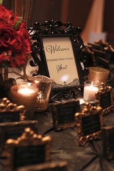 a table topped with candles and framed pictures