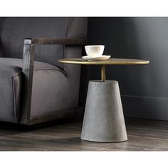 a coffee table with a cup on it next to a gray couch and chair in a living room