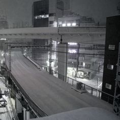 a snow covered train station with buildings in the background