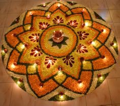 a circular arrangement of flowers and candles on the floor