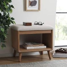 a wooden shelf with books on it next to a potted plant and eyeglasses