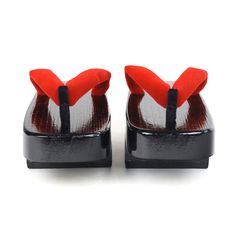 pair of red and white shoes with black soles on the bottom, side view