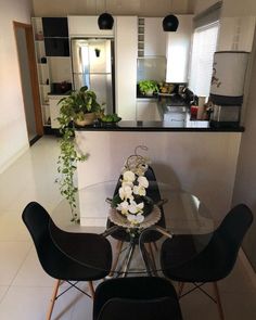 a glass table with four chairs around it in a kitchen next to a counter top