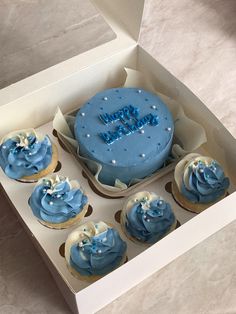 blue frosted cupcakes in a white box with happy birthday written on them