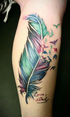 a colorful tattoo on the leg of a woman's legs with a feather and butterflies