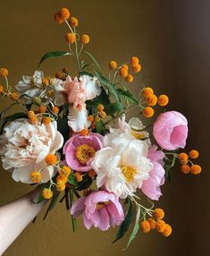 a person holding a bouquet of flowers in their hand